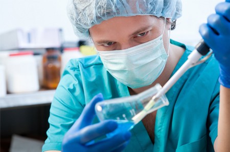 Photo of a Covance scientist working with a beaker containing drug samples.