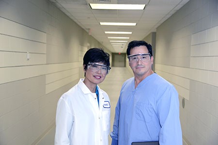 General toxicology studies at Covance. Photo of scientists walking and talking in a hallway.